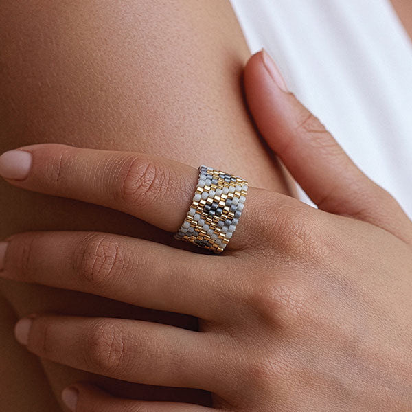 Handmade Miyuki bead ring in silver, gold, and ivory geometric pattern worn on finger with 24K gold plated beads