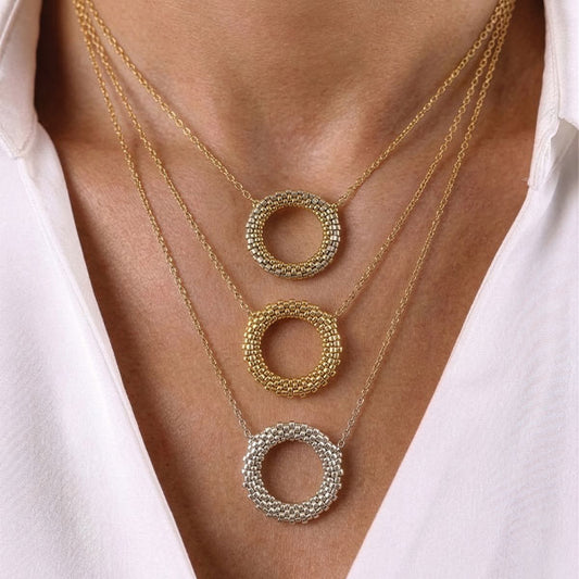 Handmade Miyuki bead circular pendant necklaces in gold, champagne gold, and silver tones layered on neck with 24K gold plated beads