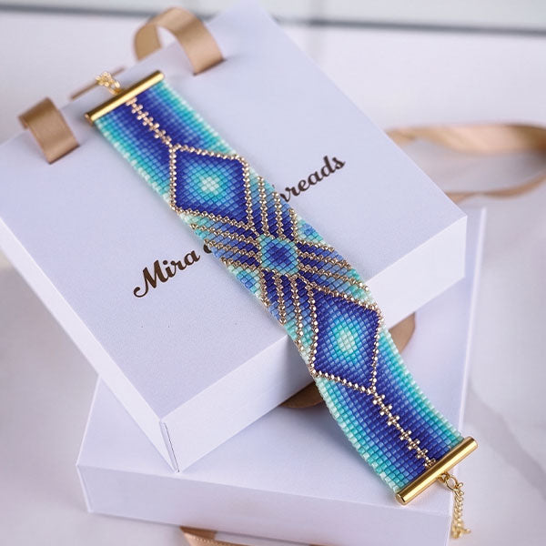 Handmade Miyuki bead bracelet with radiant geometric pattern in turquoise, aqua, blue, and violet tones featuring 24K gold plated beads