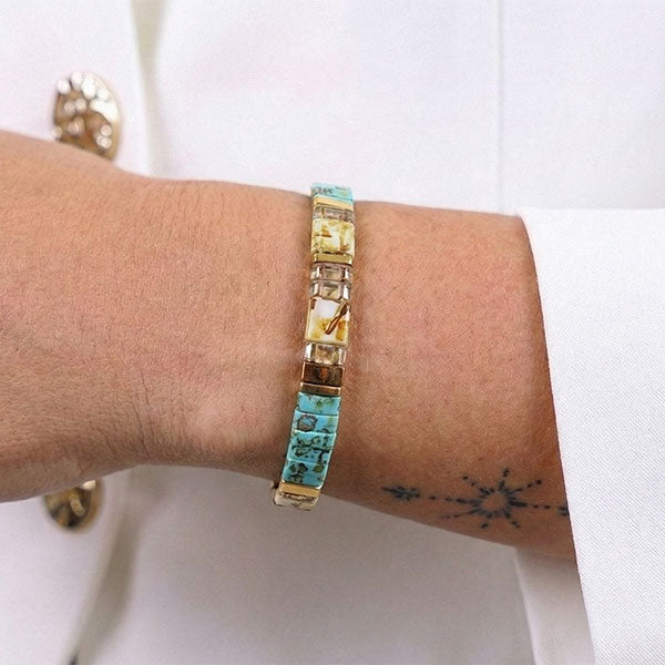 Handmade Miyuki Tila bead bracelet with turquoise tones and 24K gold-plated accents in a flat geometric design