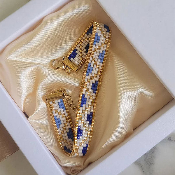 Handmade Miyuki bead bracelet in ivory and blue geometric pattern with 24K gold plated beads displayed on gift box