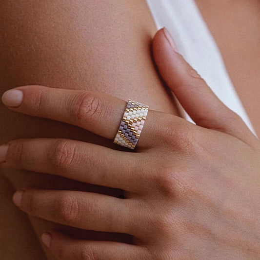 Handmade Miyuki bead ring in ivory, lavender, and gold tones with geometric pattern and 24K gold plated beads worn on finger