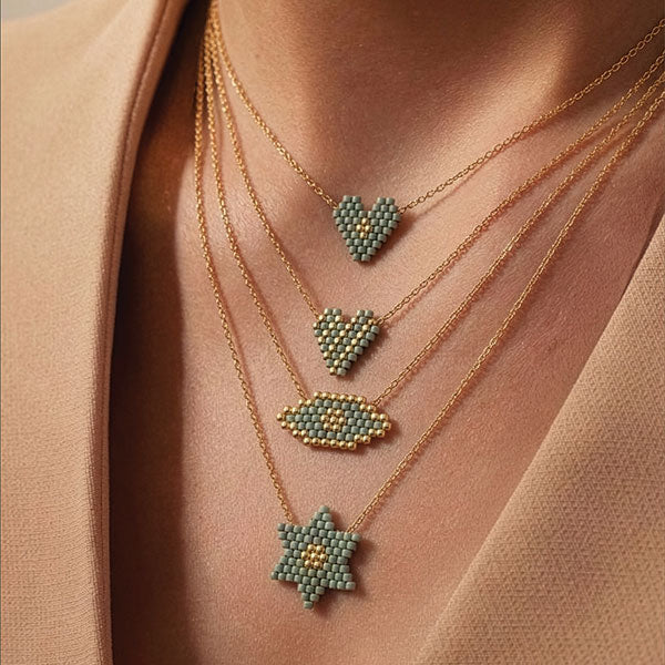 Layered handmade Miyuki bead necklaces with green heart, double heart, eye, and star pendants with 24K gold plated beads