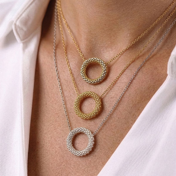 Handmade Miyuki bead circular pendant necklaces in gold, champagne gold, and silver tones layered on neck with 24K gold plated beads