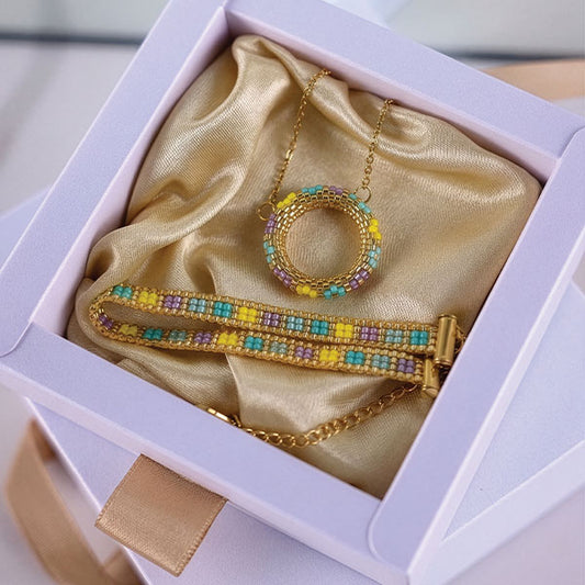 Handmade Miyuki bead necklace and bracelet set in turquoise, yellow, and lavender tones with gold accents and 24K gold plated elements displayed in gift box