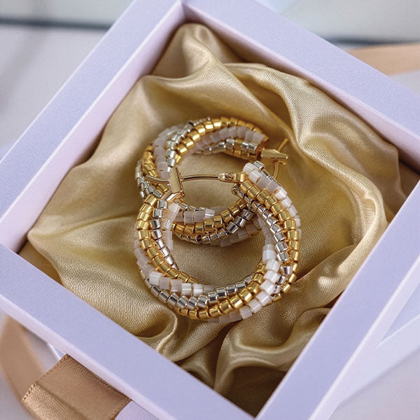 Handmade Miyuki bead hoop earrings in gold, ivory, and silver tones with 24K gold plated elements displayed in gift box