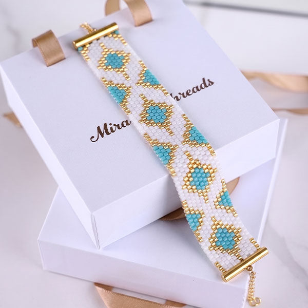 Handmade Miyuki bead bracelet in turquoise, ivory and gold with geometric medallion pattern and 24K gold plated beads
