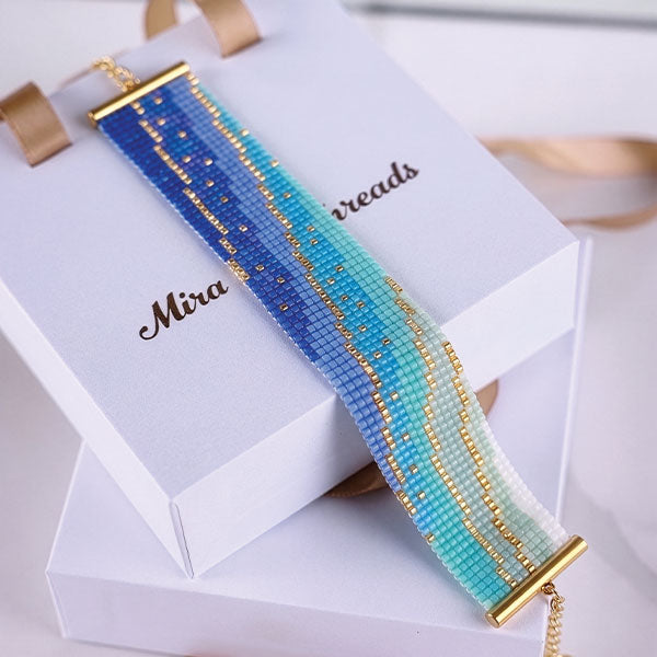 Handmade Miyuki bead bracelet with blue, aqua, turquoise, and ivory gradient pattern featuring 24K gold plated beads