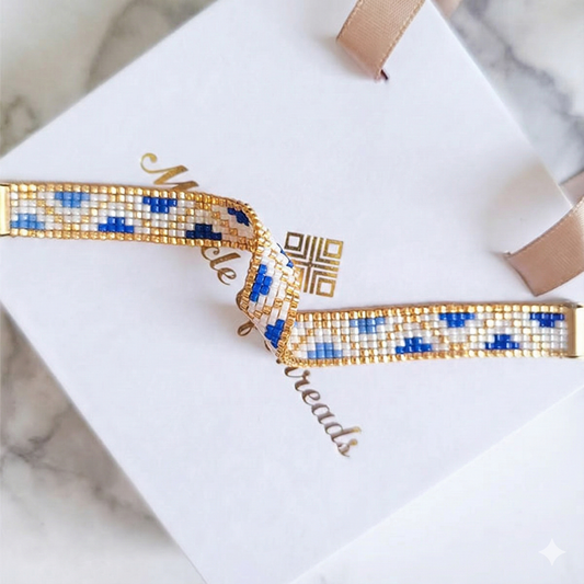Handmade Miyuki bead bracelet in ivory and blue geometric pattern with 24K gold plated beads displayed on gift box