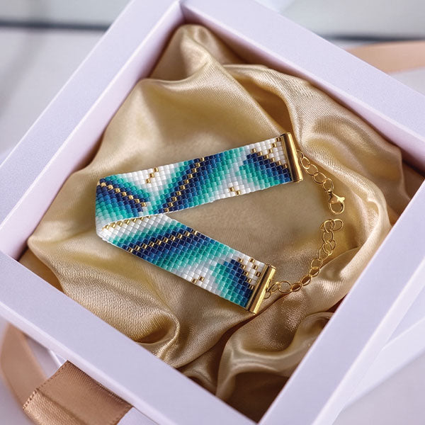 Handmade Miyuki bead bracelet with turquoise, aqua, blue, and ivory geometric wave pattern featuring 24K gold plated beads