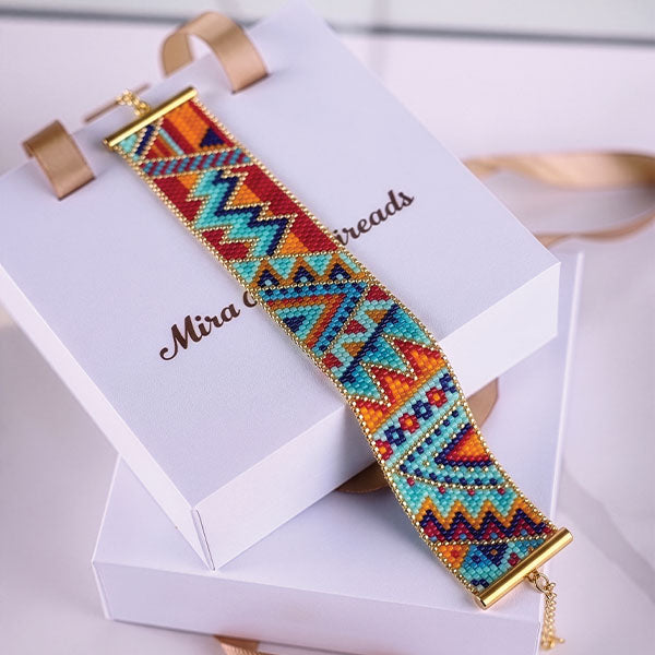 Handmade Miyuki bead bracelet with colorful tribal geometric pattern in turquoise, orange, red, and blue tones featuring 24K gold plated beads