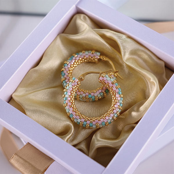 Handmade Miyuki bead hoop earrings in pastel turquoise, pink, ivory, and gold tones with 24K gold plated elements displayed in gift box