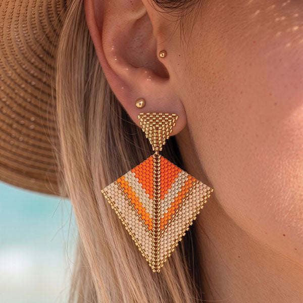 Handmade geometric Miyuki bead earrings in ivory, orange, and gold tones with 24K gold plated elements displayed in gift box