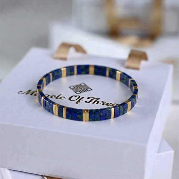 Handmade Miyuki Tila bead bracelet with blue tones and 24K gold-plated beads in a geometric flat design