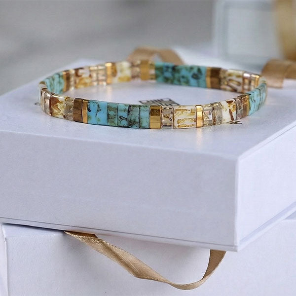 Handmade Miyuki Tila bead bracelet with turquoise tones and 24K gold-plated accents in a flat geometric design