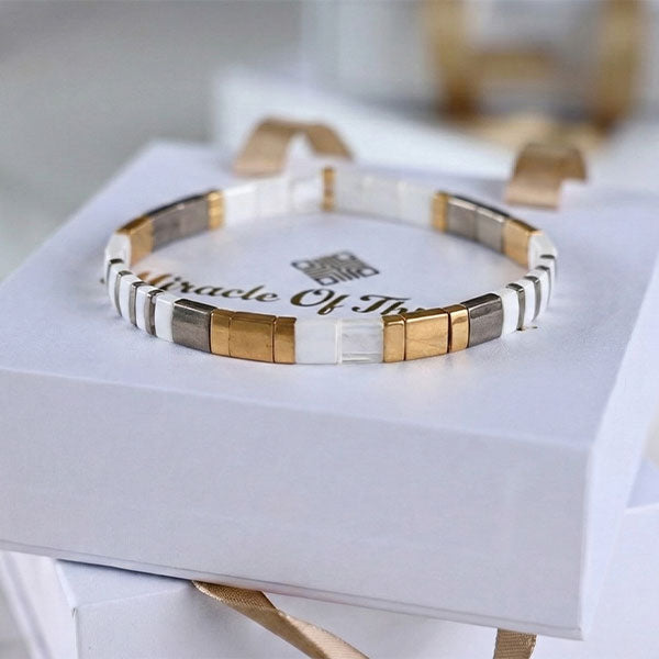 Handmade Miyuki Tila bead bracelet with ivory, silver, and 24K gold-plated beads in a geometric flat design