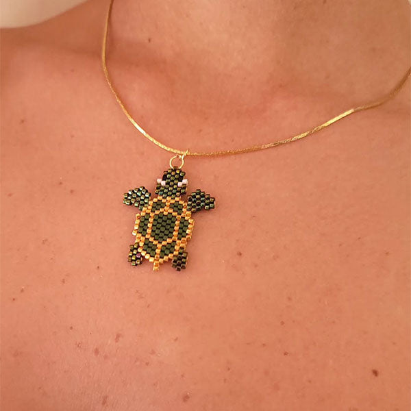 Handmade Miyuki bead turtle necklace in green and gold tones with 24K gold plated beads on delicate gold chain
