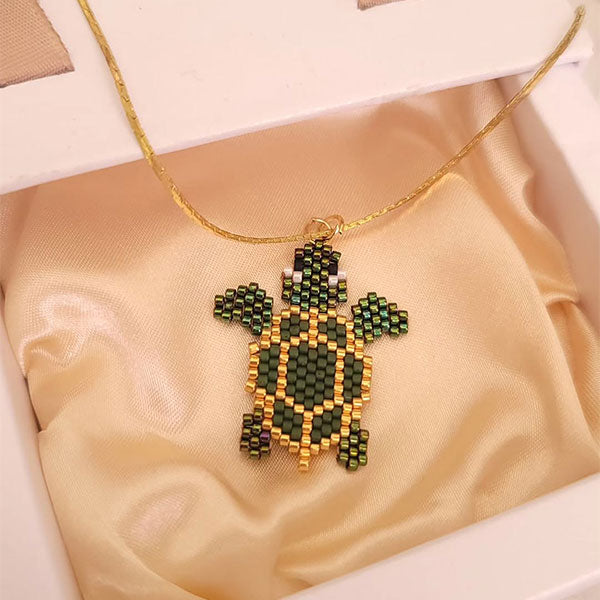 Handmade Miyuki bead turtle necklace in green and gold tones with 24K gold plated beads on delicate gold chain