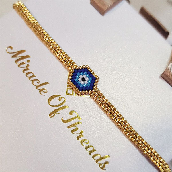 Handmade Miyuki bead bracelet with blue eye motif and gold band featuring 24K gold plated beads