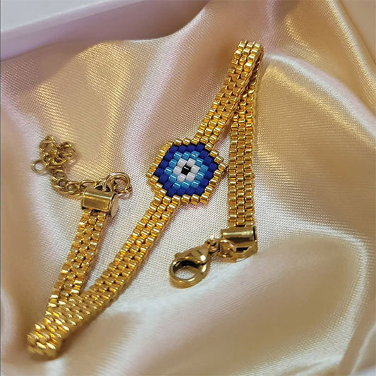Handmade Miyuki bead bracelet with blue eye motif and gold band featuring 24K gold plated beads
