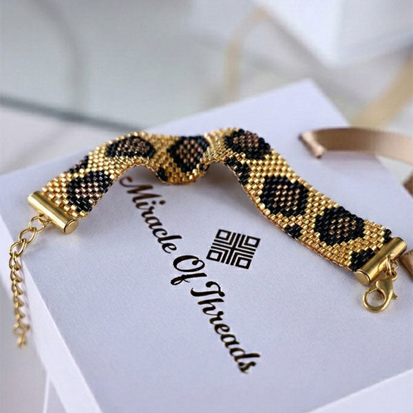 Handmade Miyuki bead bracelet in black and gold with panther-inspired pattern and 24K gold-plated beads