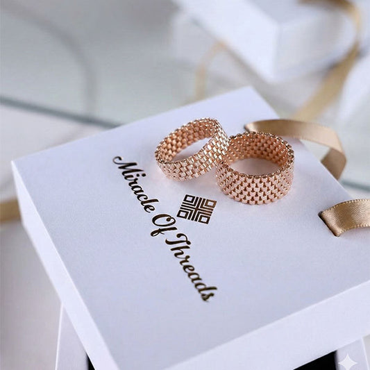 Handmade rose gold Miyuki bead rings on luxury jewelry box